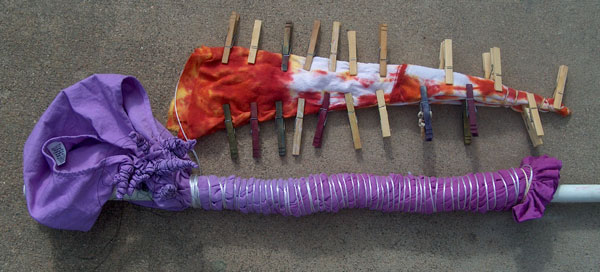 shibori resist dye preparation with string around a pole and clothespins